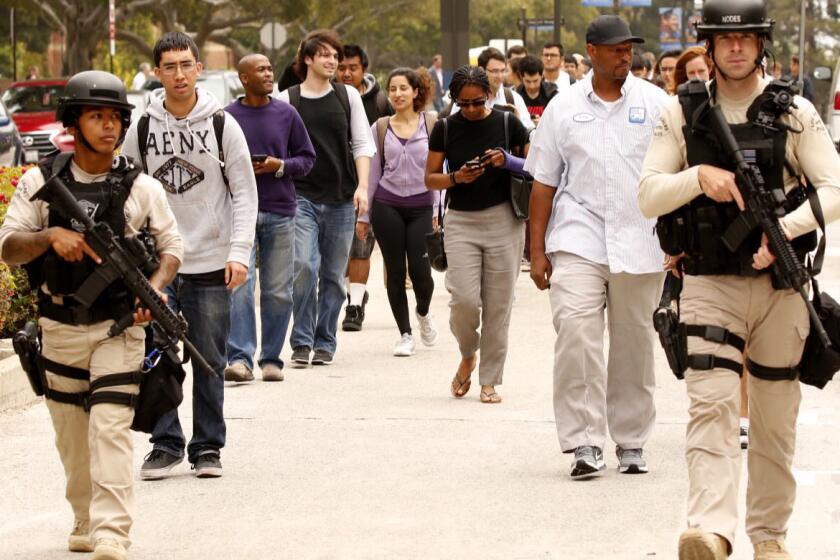 Police escort people at UCLA after a lockdown was lifted following a shooting on campus.