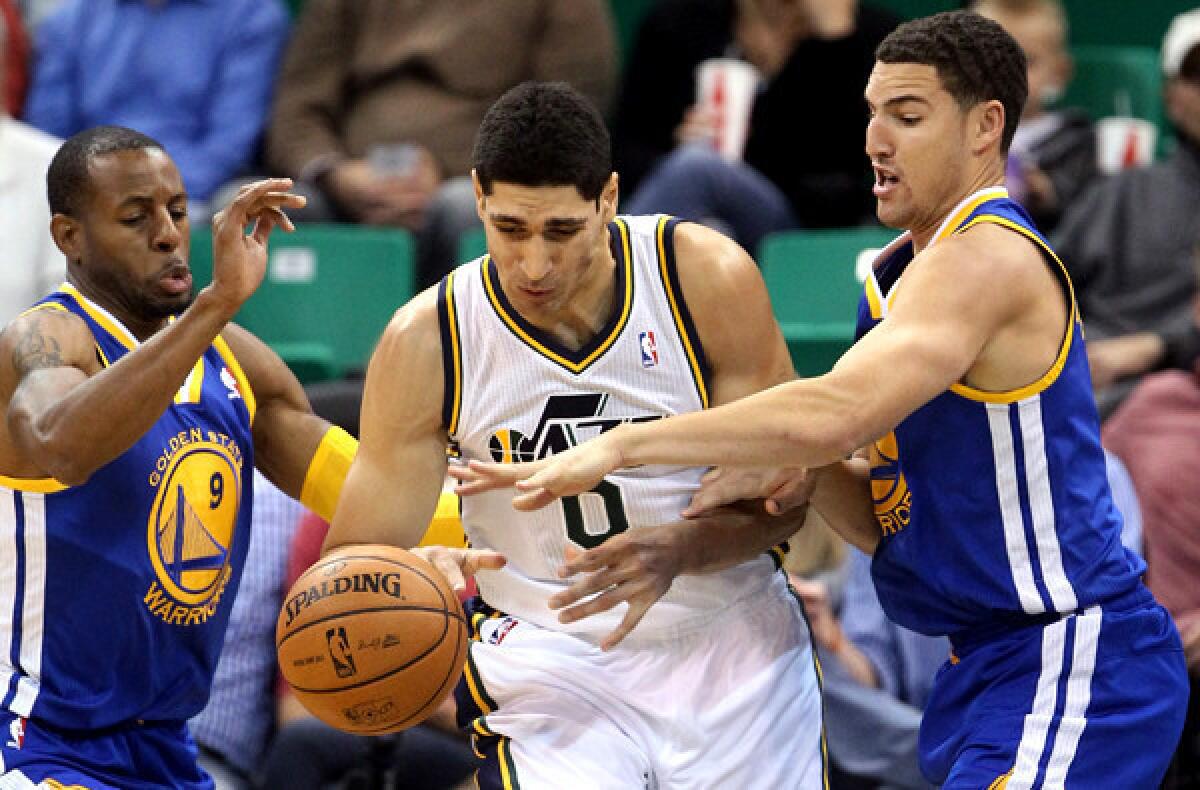 Golden State's Andre Iguodala, left, and Klay Thompson try to steal the ball from Jazz center Enes Kanter during a preseason game.