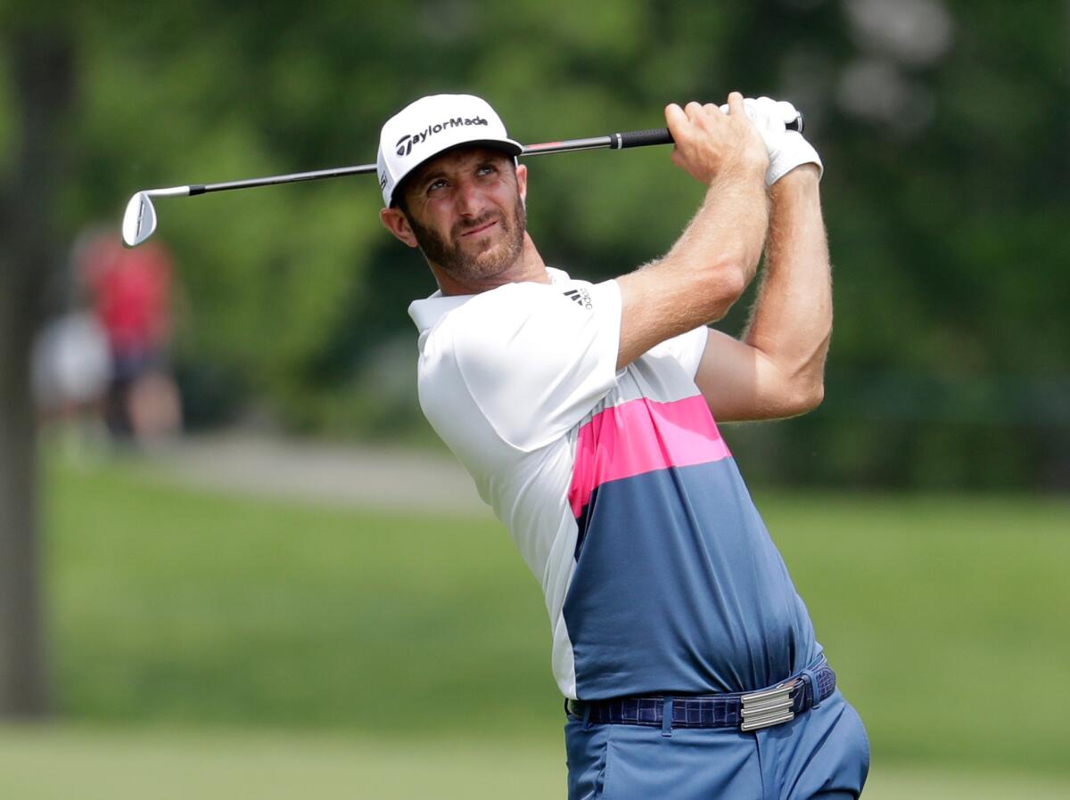 Dustin Johnson hits his second shot on the 14th hole during the first round of the Memorial tournament at Muirfield Village Golf Club in Dubln, Ohio.