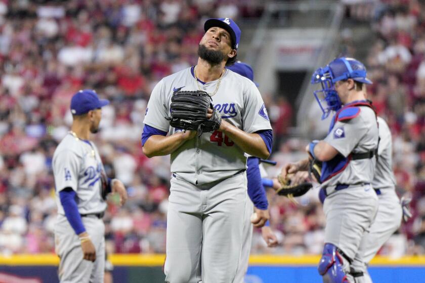 Los Angeles Dodgers pitcher Yohan Ramírez, center, leaves after a pitching change.