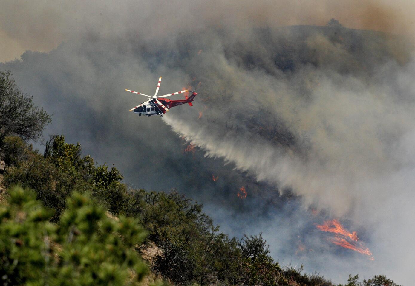 Water is dropped from a helicopter onto a hot spot at a fire in the Glenoaks and Chevy Chase canyons in Glendale on Friday, May 3, 2013. Hundreds of homes were evacuated.