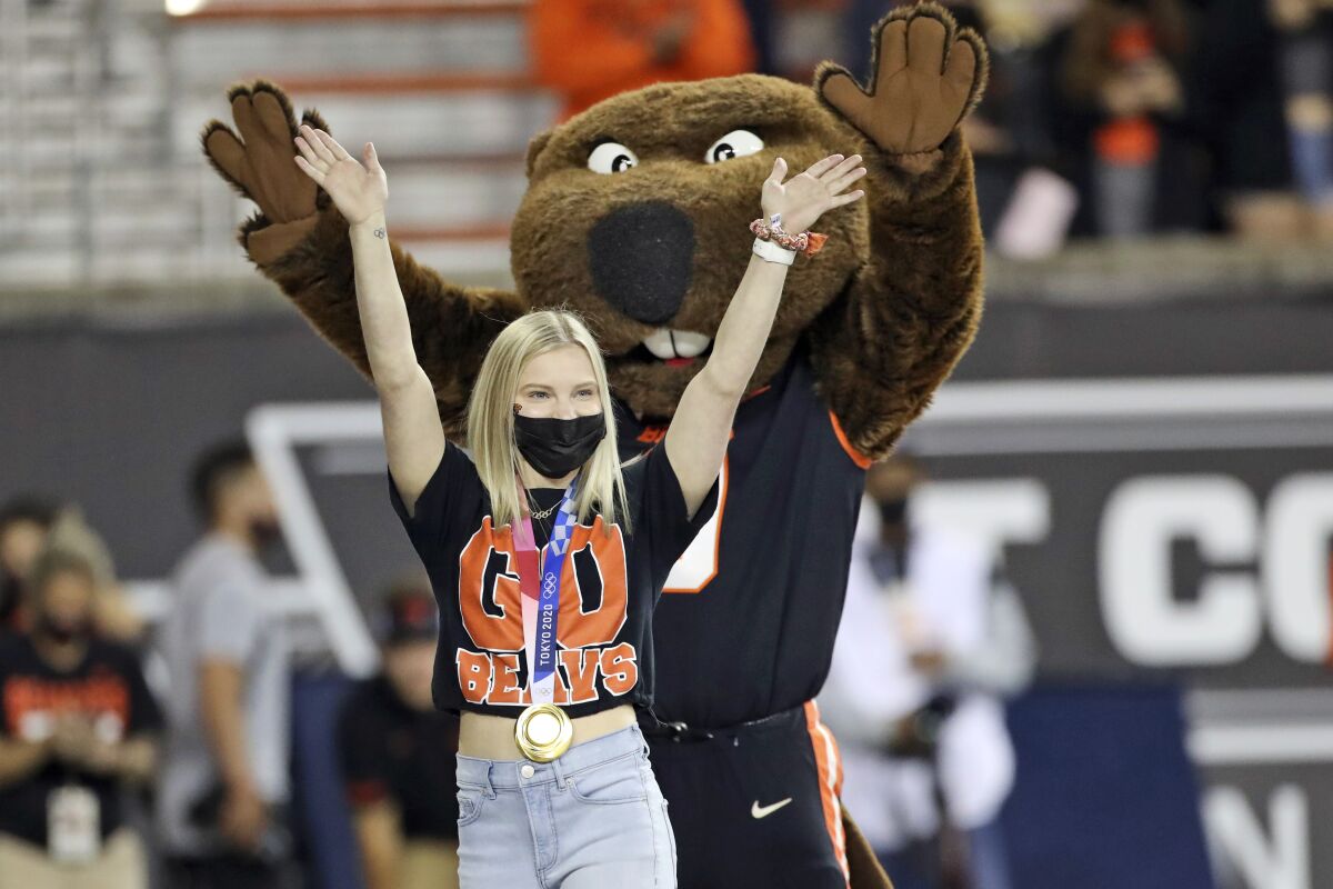 FILE - In this Saturday, Sept. 11, 2021, file photo, U.S. Olympic gold medal gymnast and incoming Oregon State student Jade Carey waves to the crowd during a timeout in the first half of an NCAA college football game between Oregon State and Hawaii in Corvallis, Ore. Carey is finally embarking on her freshman year at Oregon State, after taking a somewhat winding route to Corvallis. Then again, the 21-year-old Olympic gold medalist is used to taking the non-traditional path. (AP Photo/Amanda Loman, File)