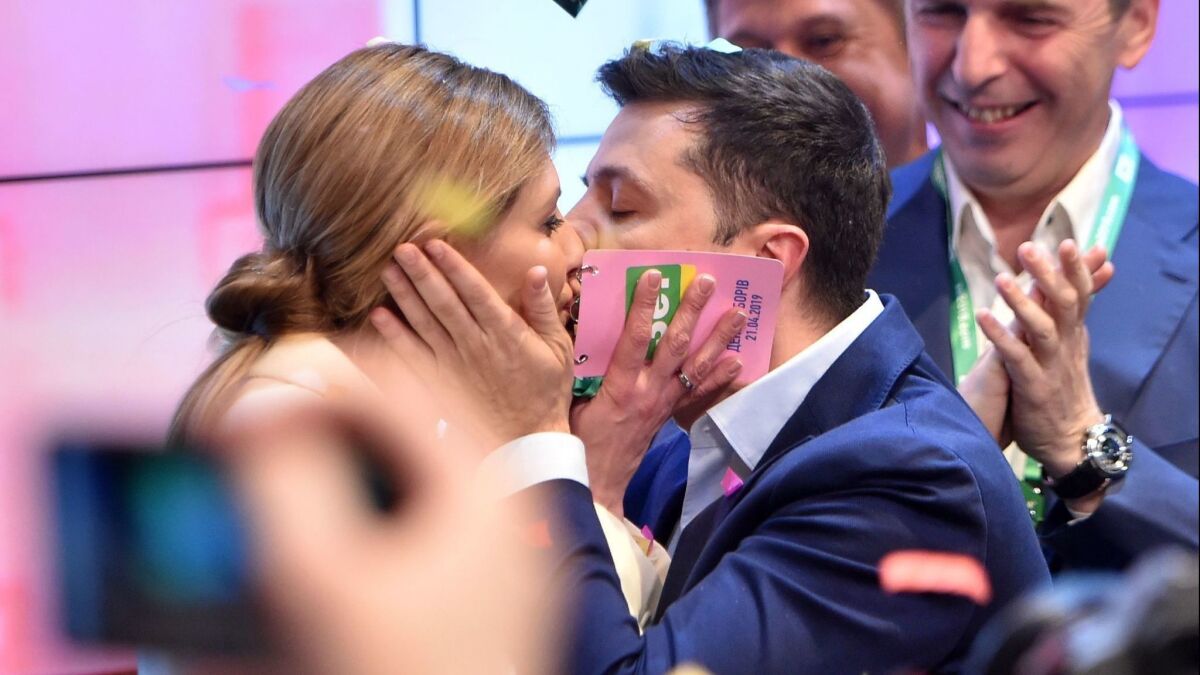 Ukrainian president-elect Volodymyr Zelensky kisses his wife Olena after the announcement of the first exit poll results in Ukraine's presidential election at his campaign headquarters in Kiev on April 21.