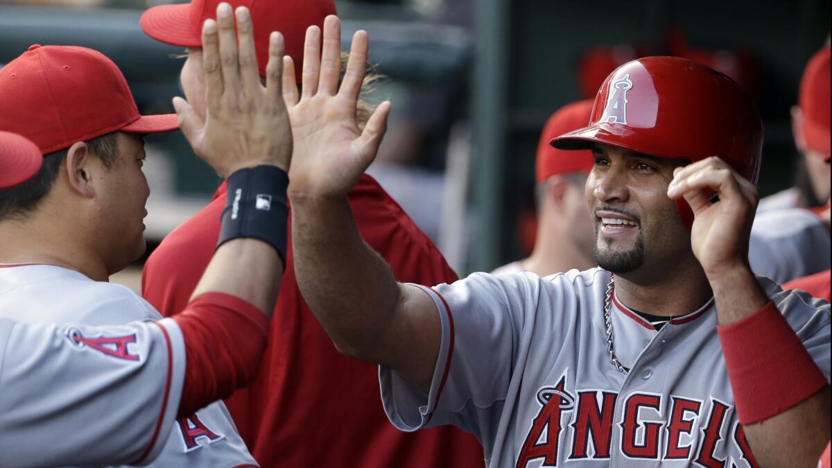 Angels first baseman Albert Pujols, right, celebrates with his teammates after scoring during the first inning of an 8-1 win over the Texas Rangers on Wednesday.