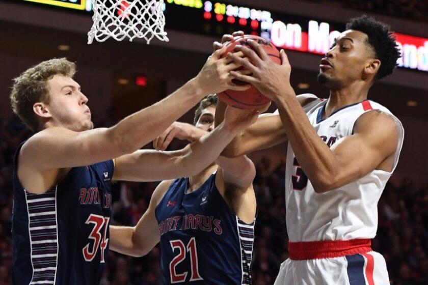 Saint Mary's forwards Jock Landale (34) and Evan Fitzner (21) battle with Gonzaga forward Johnathan Williams (3) for a rebound during the WCC tournament championship game in Las Vegas on Mar. 7.