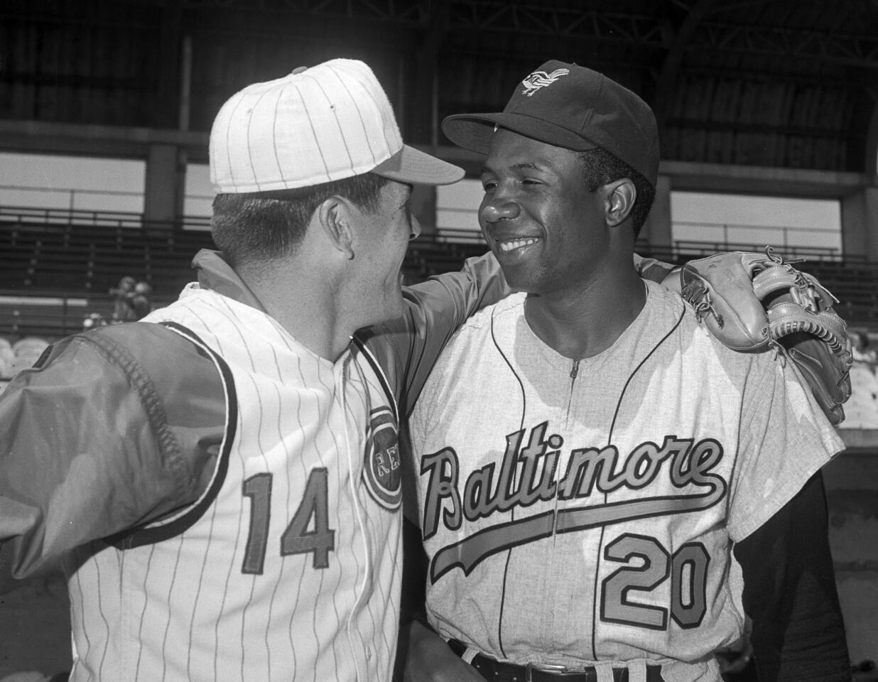 The Cincinnati Reds' Pete Rose, left, greets Frank Robinson of the Orioles before a spring training game, in Tampa, Fla., on April 1, 1966.
