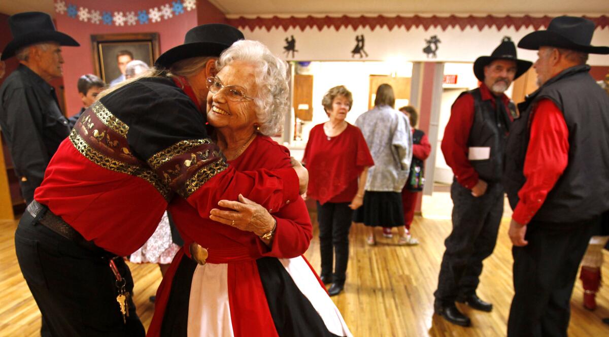 Reid Fahring, left, 63, of Fontana, hugs Lena Henderson, 85, of Riverside, after the last dance of the night at Cowtown.