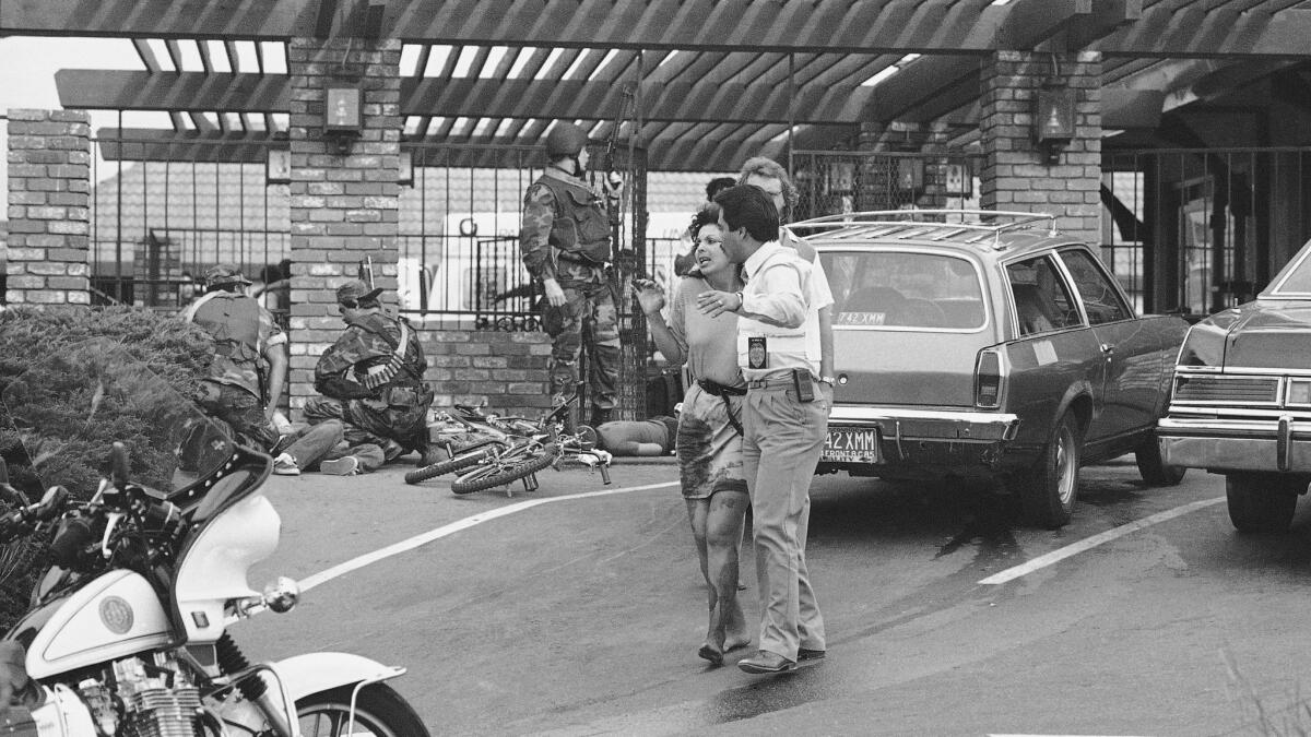 A wounded victim is led away from the scene of a mass shooting at a McDonald’s in San Ysidro, Calif., in 1984.