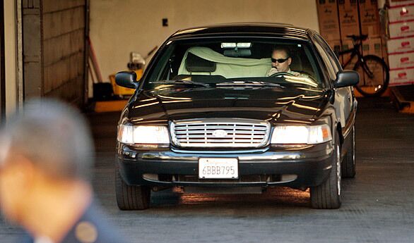 A car presumably carrying Lindsay Lohan (behind the white towel) is driven away from the courthouse in Beverly Hills after a judge orders her to jail.