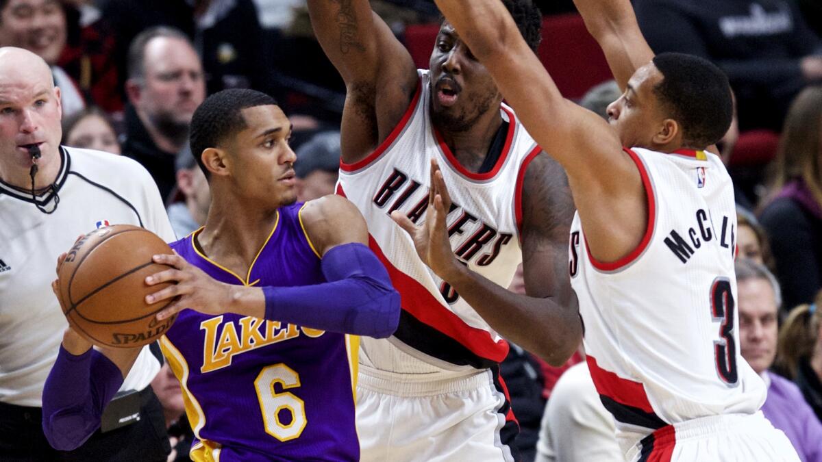 Lakers guard Jordan Clarkson looks to pass out of the double-team defense of Trail Blazers forward Al-Farouq Aminu, center, and guard C.J. McCollum during the second half Thursday.