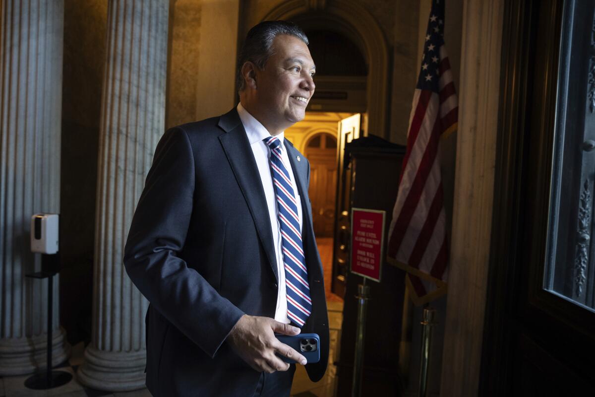 Sen. Alex Padilla walks down a hall at the U.S. Capitol.