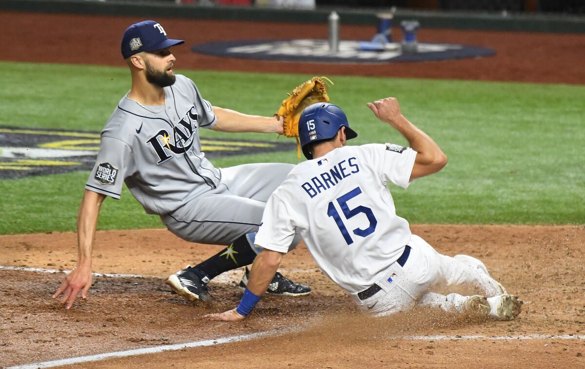 Dodgers catcher Austin Barnes scores in front of Tampa Bay Rays pitcher Nick Anderson on a wild pitch.