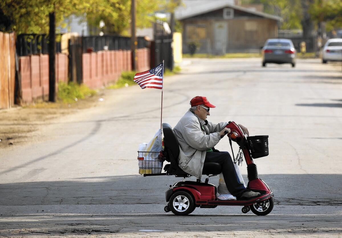 Trump supporter Leonard McGill, 73, flies the American flag from his scooter as he rides through Oildale.
