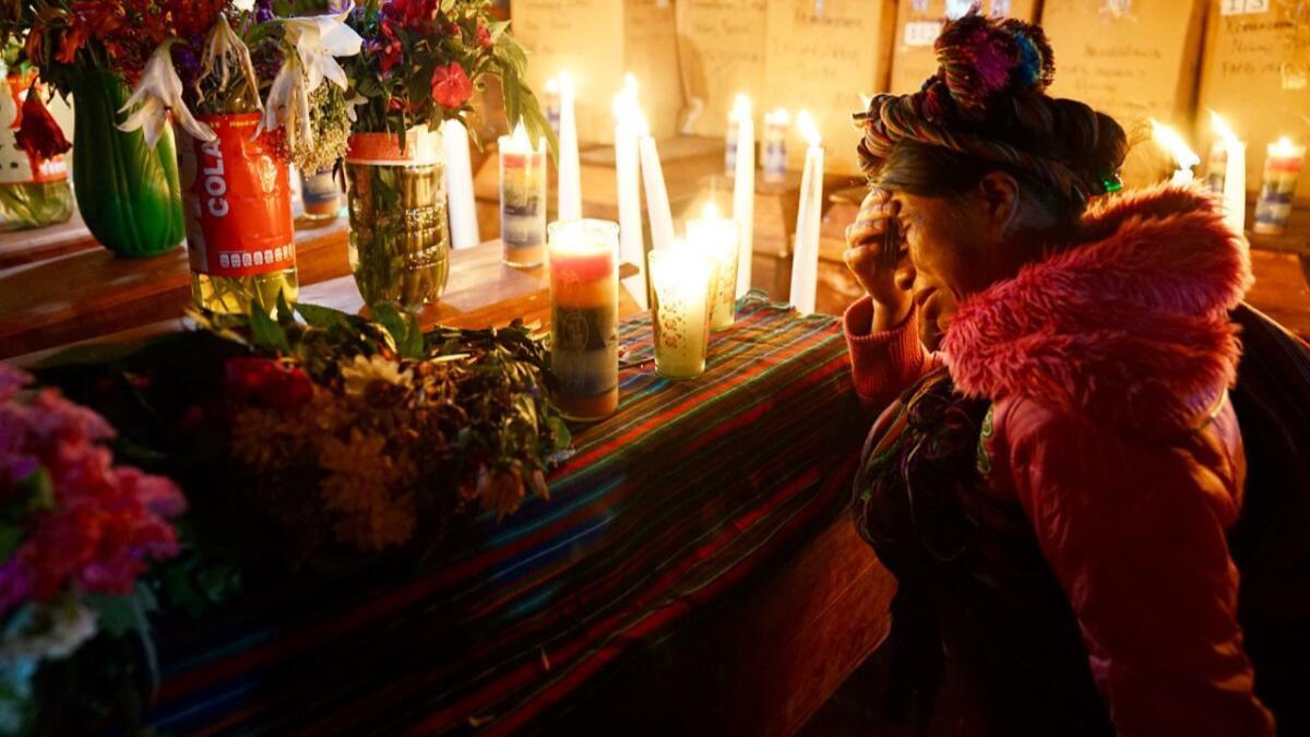 Petrona Raymundo Rivera mourns at the coffin of her father, Pedro Rivera Copo, alongside the remains of other villagers who died during Guatemala's military rule in the 1980s.