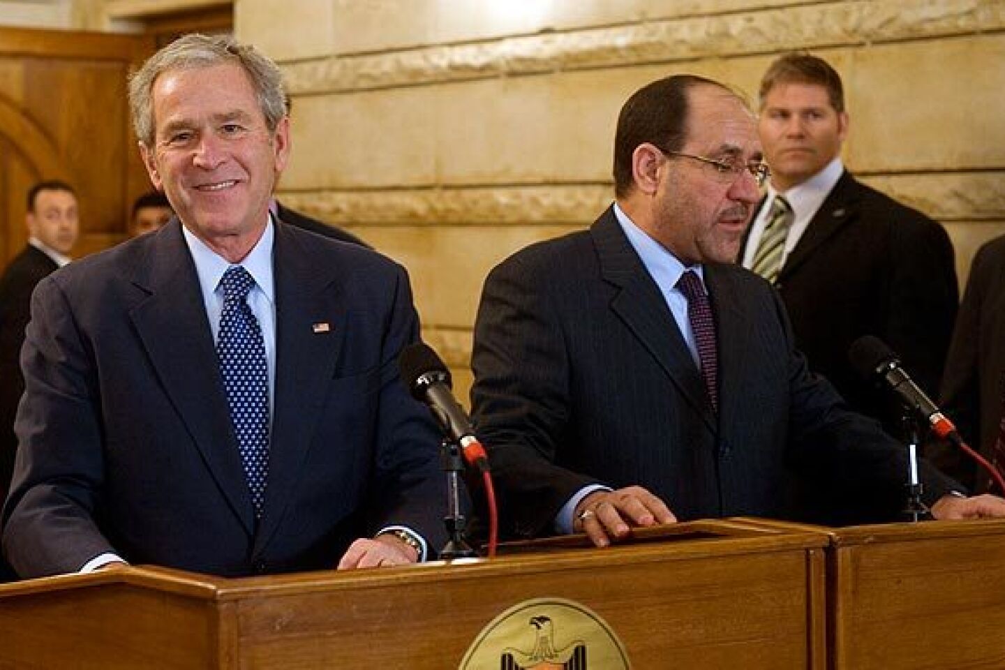 President Bush, alongside Iraq Prime Minister Nouri Maliki, is apparently unruffled and has a smile for reporters after ducking two thrown shoes at a news conference.