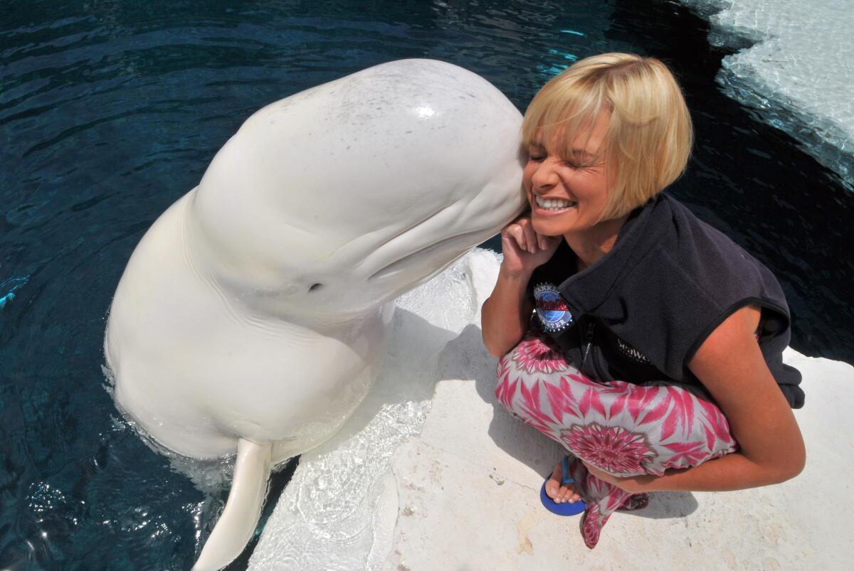 Actor Jaime Pressly gets a kiss from Ferdinand the beluga whale at SeaWorld San Diego May 10, 2009 in San Diego, CA.