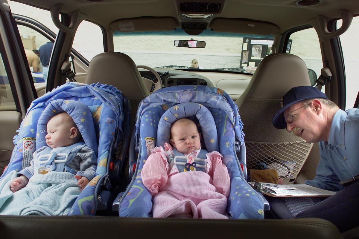 Anne Cusack -- - Three month old twins L to R Kaleb and Sarah McLaren of Oxnard get their child safety seats inspected during an inspection performed by the CHP at Babies R Us in Oxnard.