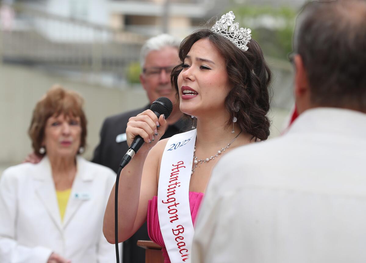 Miss Huntington Beach Princess Catherine Dosier sings the national anthem on Friday morning.