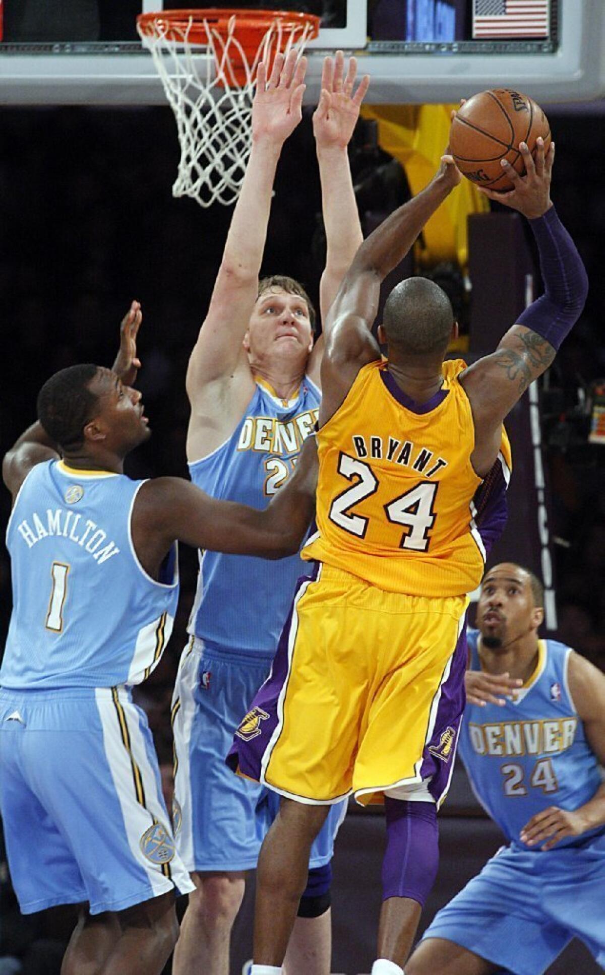 Lakers guard Kobe Bryant goes strong to the basket against Nuggets defenders Jordan Hamilton, left, Timofey Mozgov and Andre Miller in the fourth quarter on Friday.