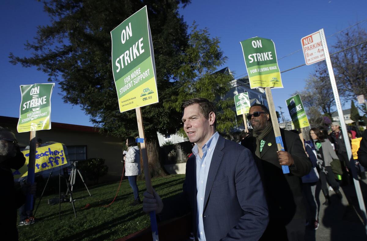 Rep. Eric Swalwell, D-Calif., center, marches along with teachers and supporters outside of Manzanita Community School in Oakland. Teachers in Oakland went on strike Thursday in the country's latest walkout by educators over classroom conditions and pay.