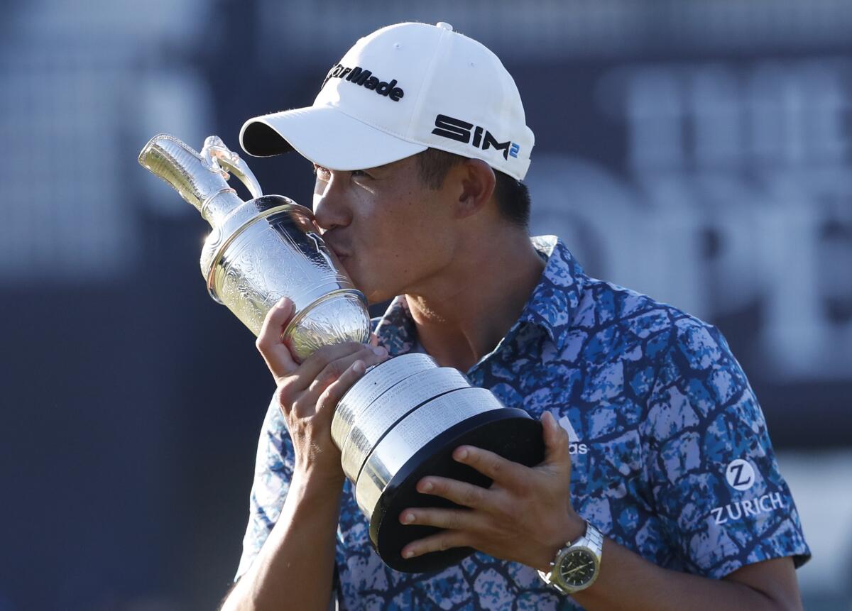 Collin Morikawa holds a trophy.