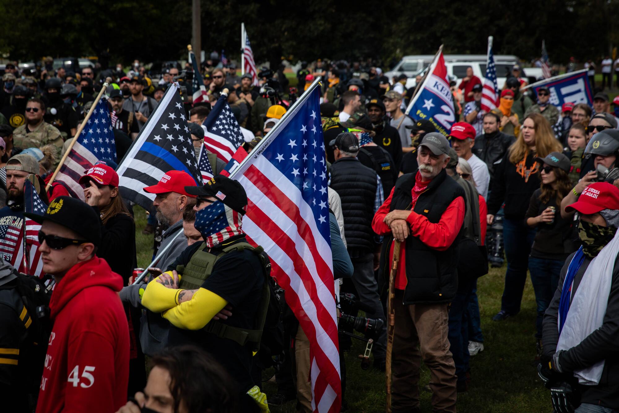 Several hundred members of the Proud Boys with U.S. flags and signs