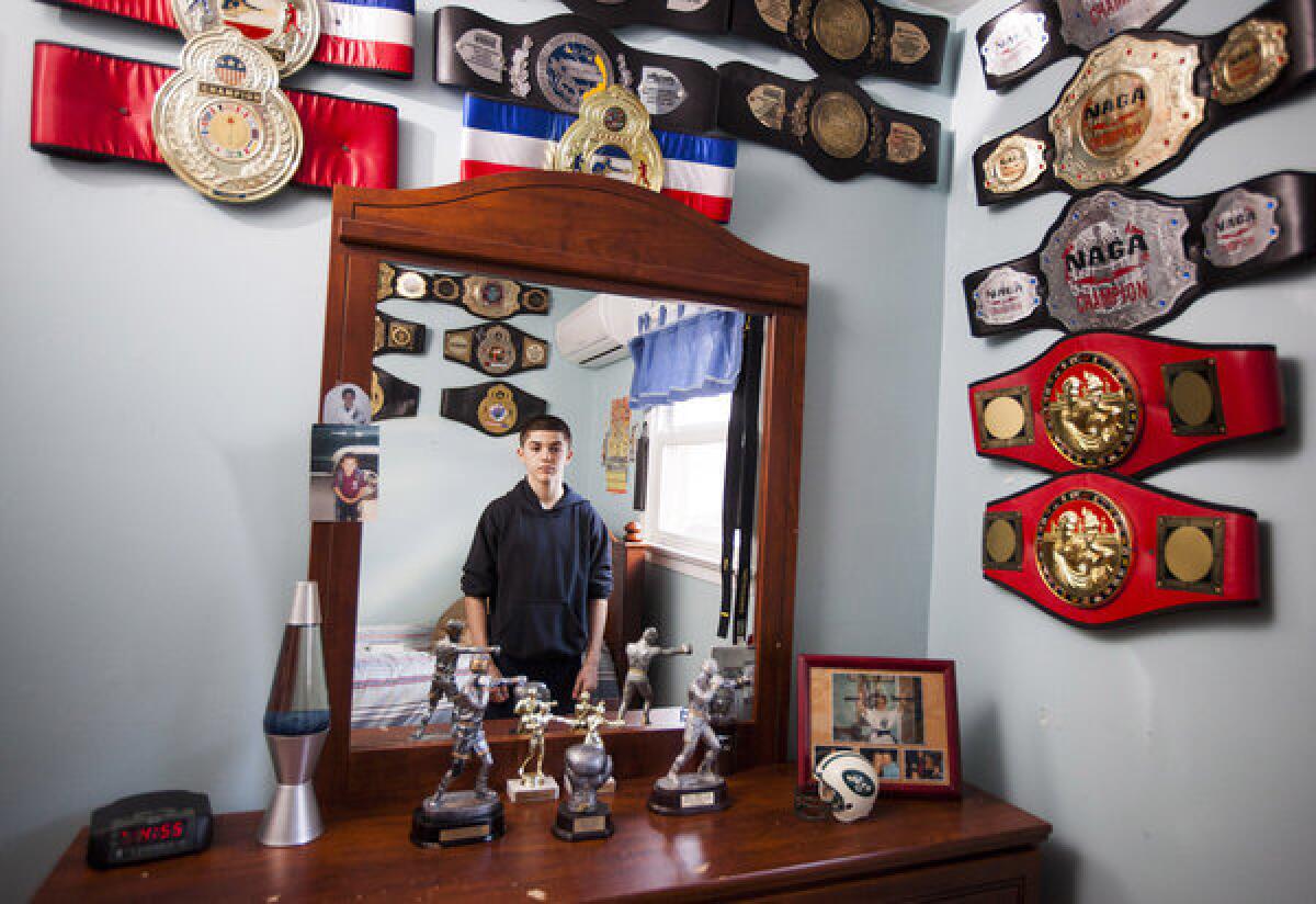 Reshat Mati poses for a portrait at home in Staten Island in his room filled with championship belts and awards. Reshat says he doesn't crave celebrity. "When I win, I'm happy," he says.