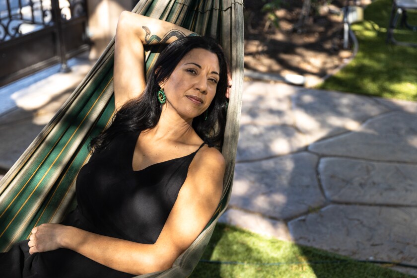Writer Lizz Huerta poses for a photo at her childhood home in Chula Vista. 