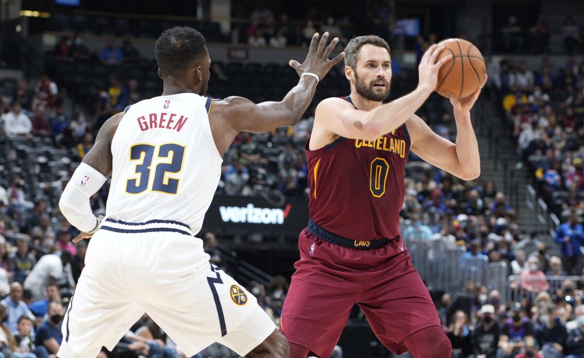 Cleveland Cavaliers forward Kevin Love, right, looks to pass the ball as Denver Nuggets forward Jeff Green defends in the first half of an NBA basketball game Monday, Oct. 25, 2021, in Denver. (AP Photo/David Zalubowski)