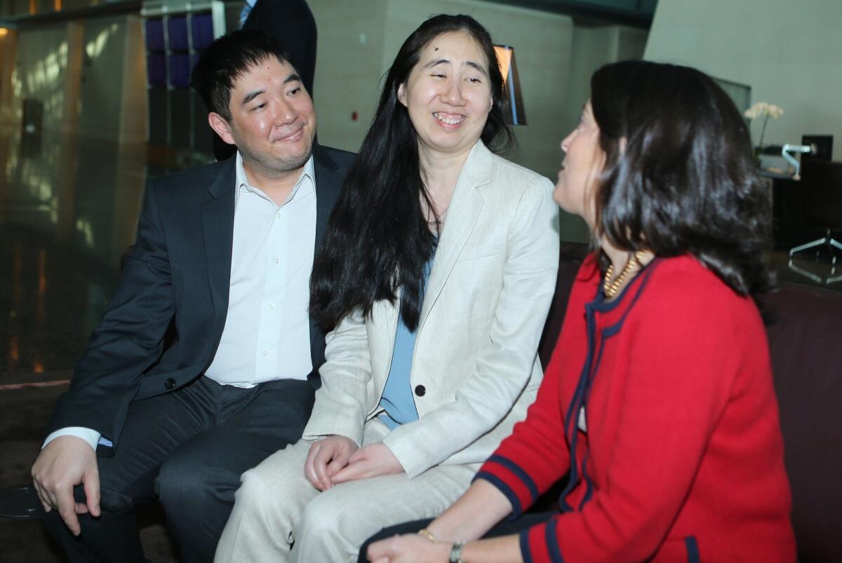US ambassador to Qatar Dana Shell Smith (R) sits next to freed US couple Grace and Matthew Huang as they wait for the departure of their flight at Doha international airport on December 3, 2014.