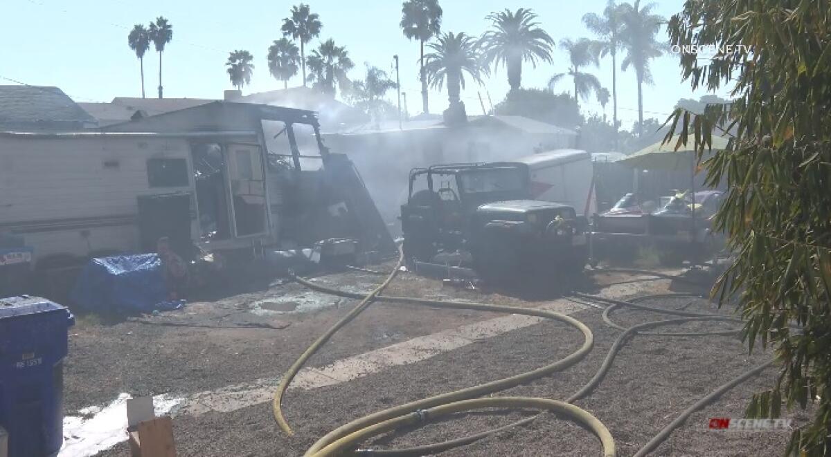 Firefighters battle a blaze Friday that burned several vehicles and at least two structures, including a garage and home