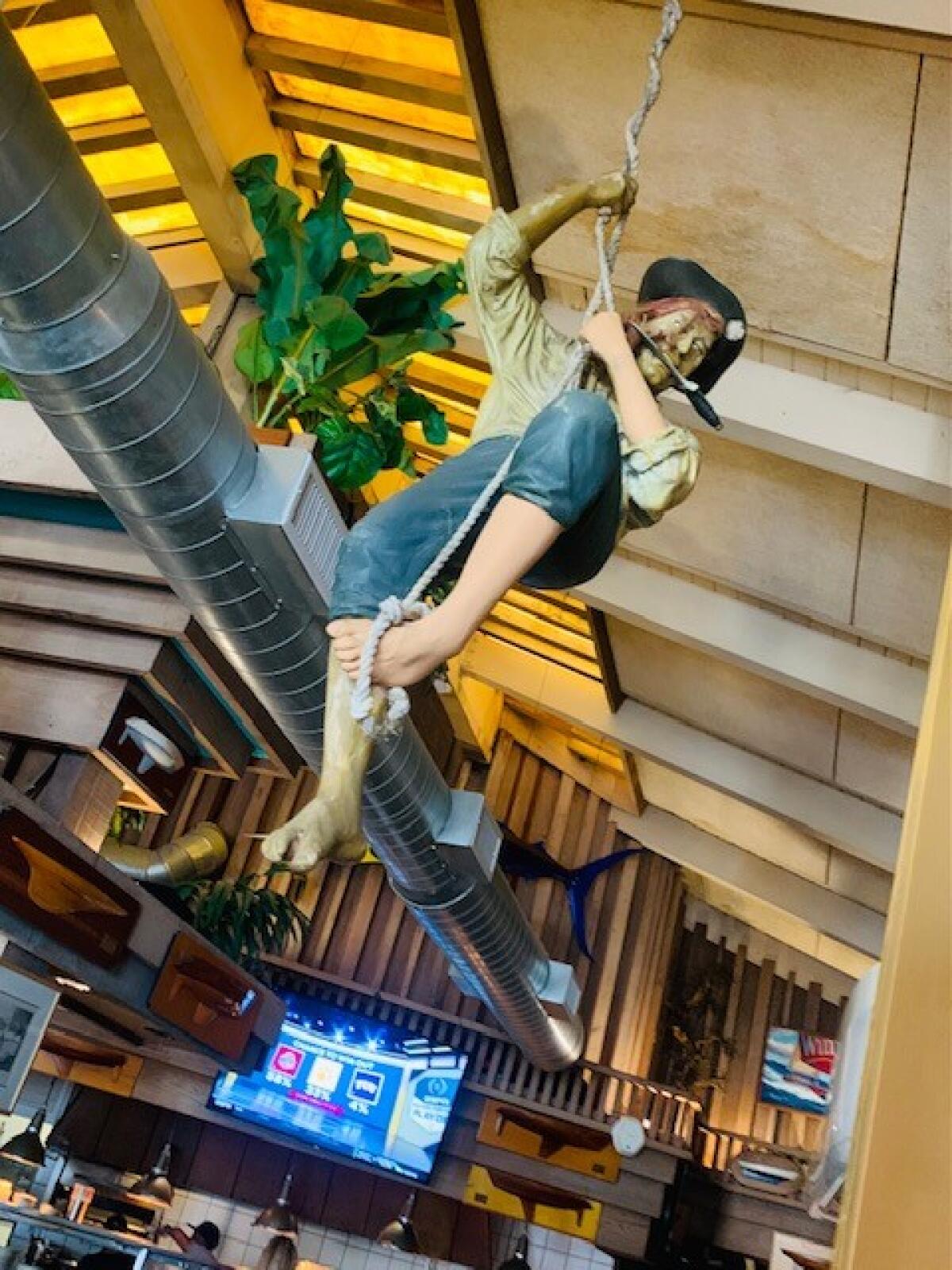 Swashbuckling pirate figures hang from the ceiling at Fiddler's Green.