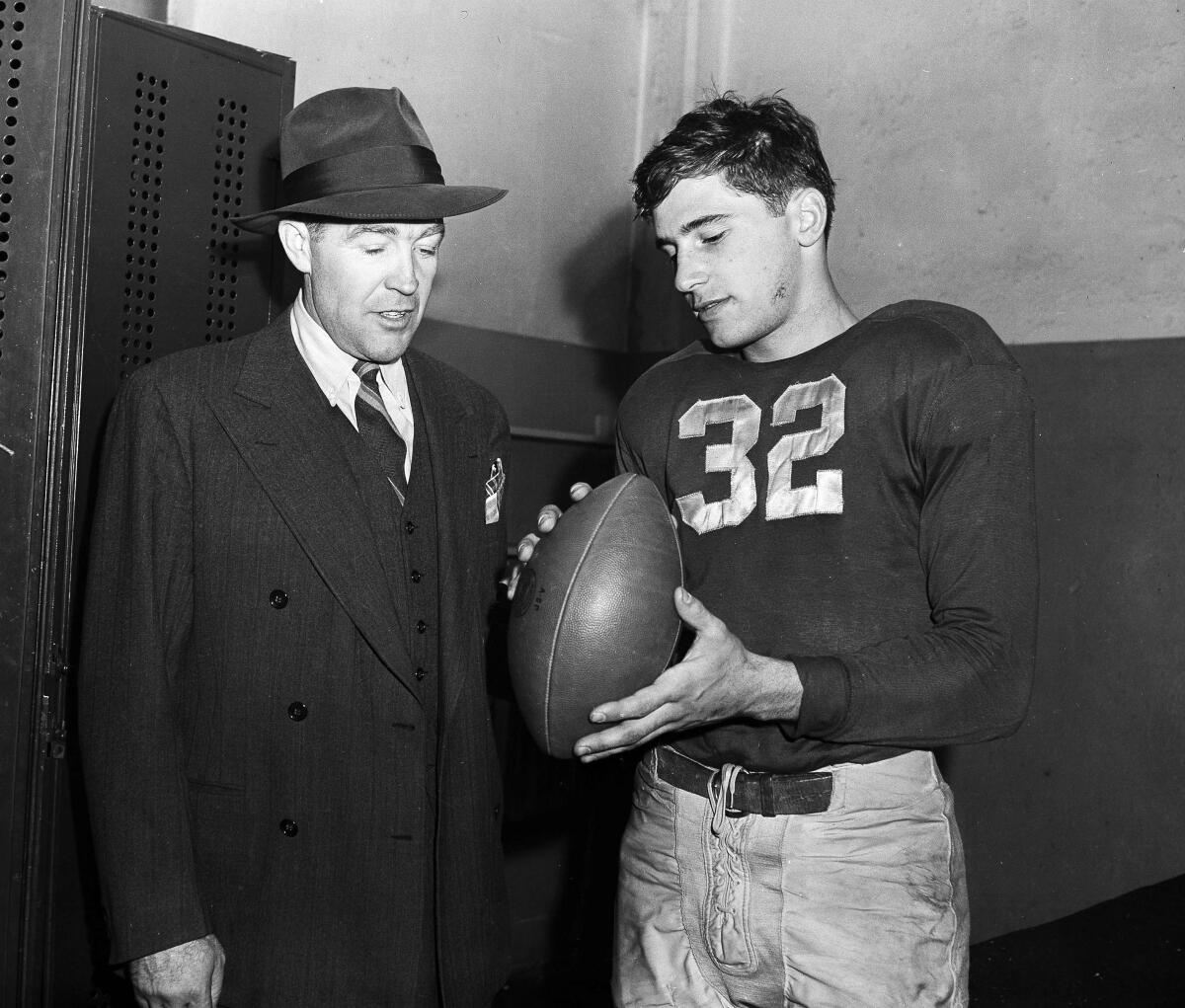 Notre Dame football coach Frank Leahy and Johnny Lujack are shown in the locker room.