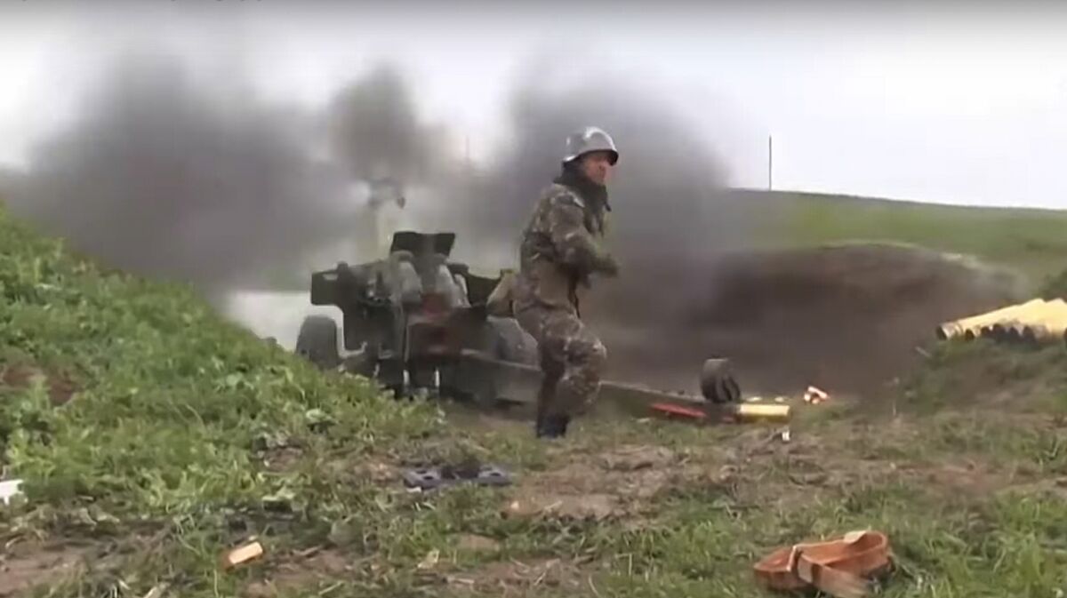 An Armenian serviceman fires a cannon toward Azerbaijani positions in Nagorno-Karabakh.