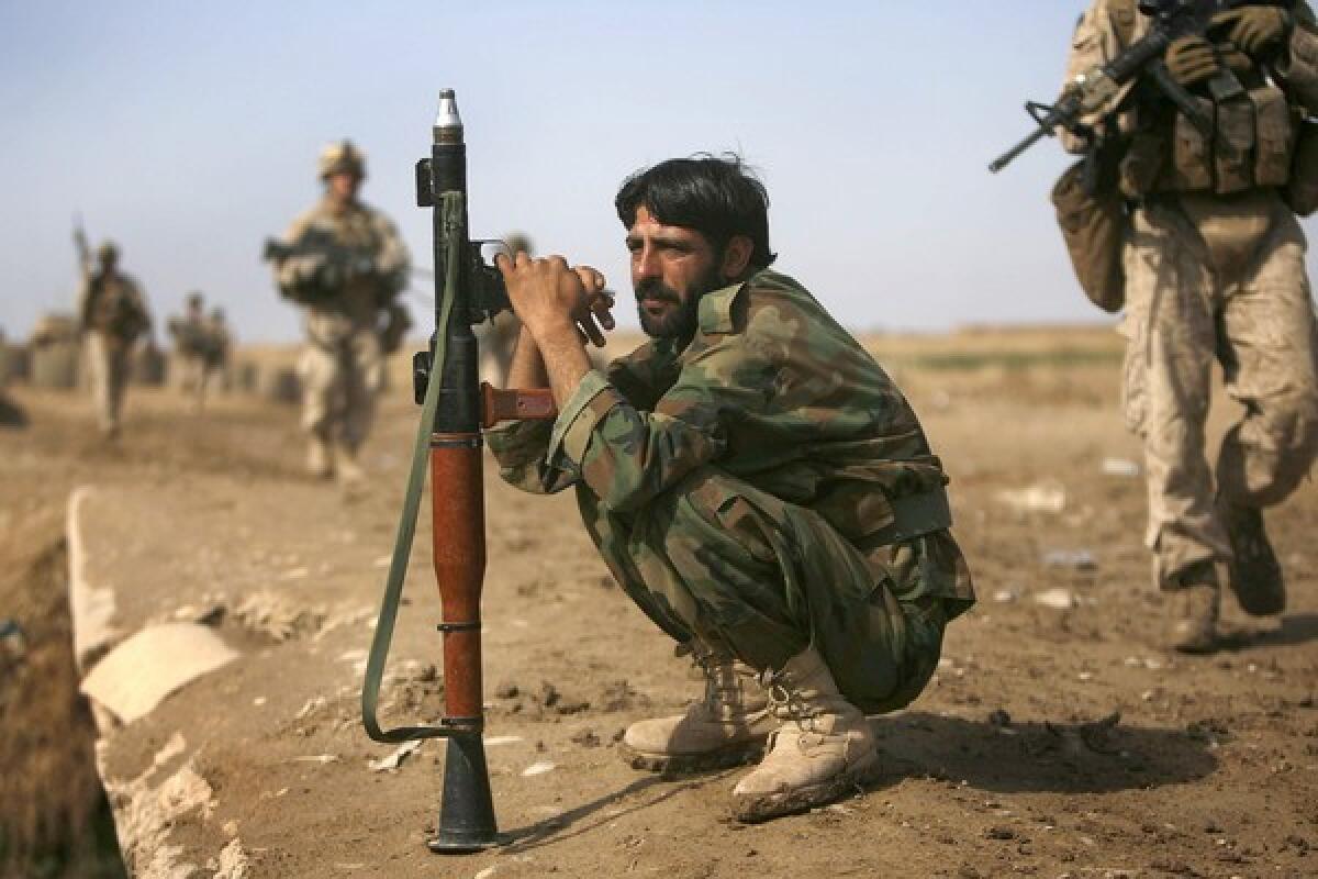 An Afghan soldier holds a rocket-propelled grenade launcher as U.S. Marines patrol on the outskirts of Marja, in Helmand province, where a massive joint assault has helped rout Taliban fighters.