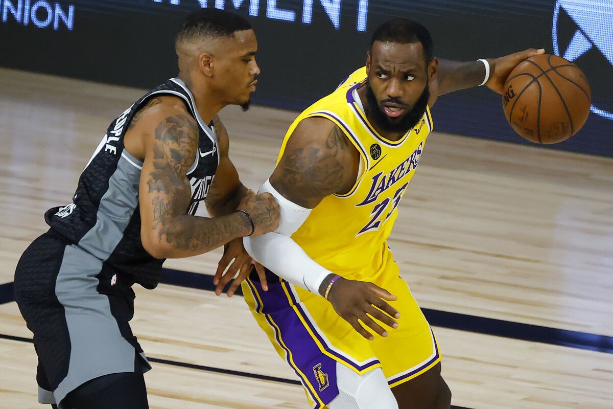 Sacramento Kings' DaQuan Jeffries, left, defends against Los Angeles Lakers' LeBron James during the second quarter of an NBA basketball game Thursday, Aug. 13, 2020, in Lake Buena Vista, Fla. (Kevin C. Cox/Pool Photo via AP)