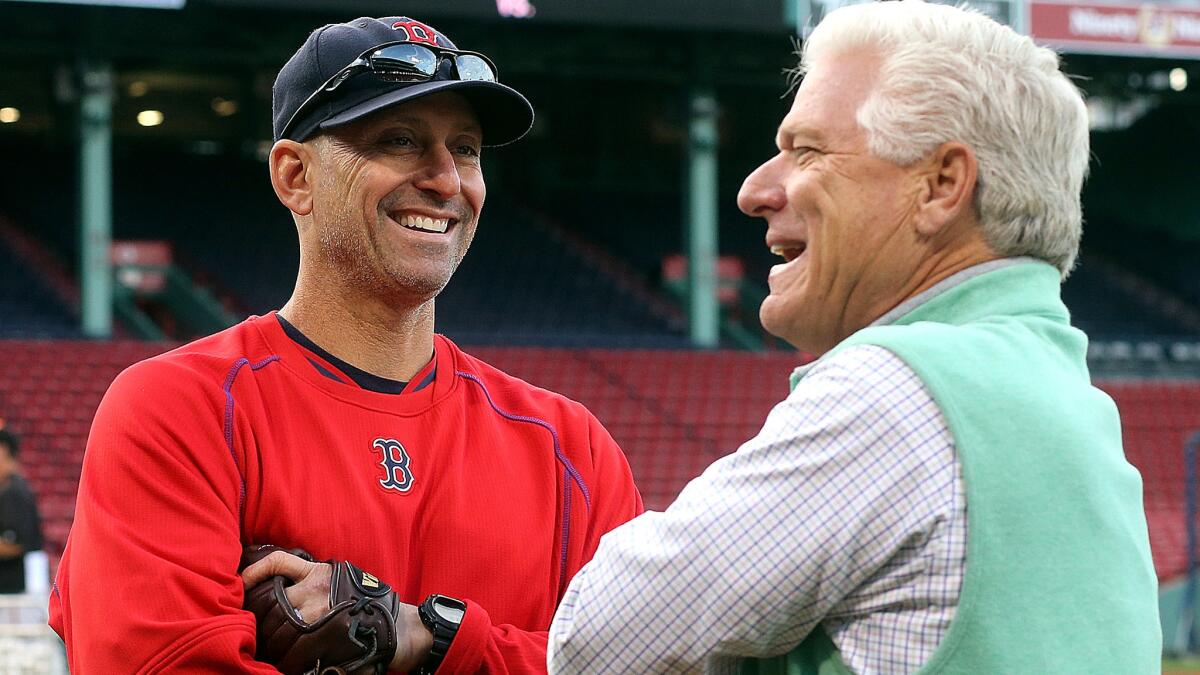 Frank Wren, who has been hired as the Boston Red Sox's vice president of baseball operations, speaks with interim manager Torey Lovullo before a game against the Baltimore Orioles on Friday at Fenway Park.