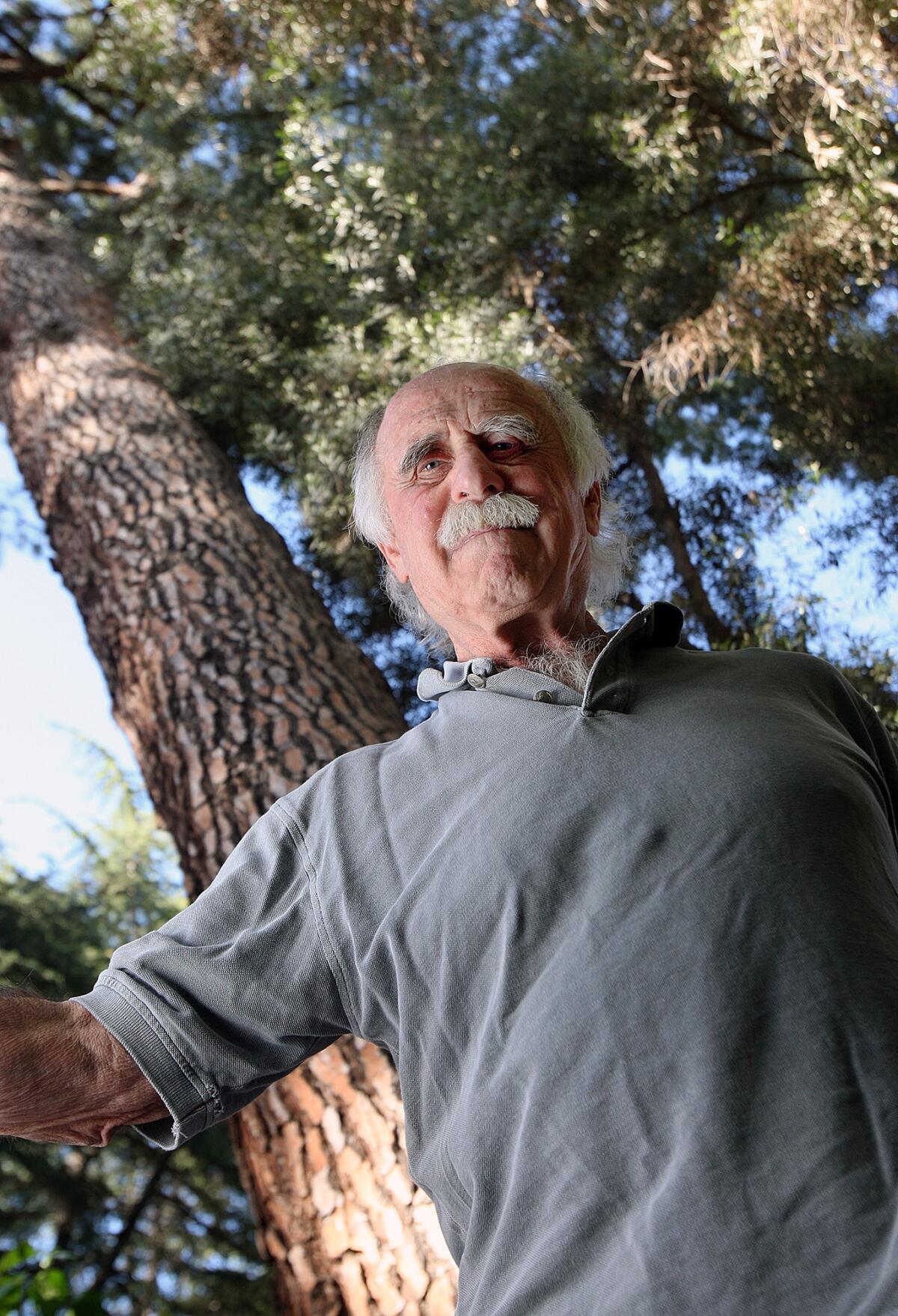 Longtime La Cañada Flintridge resident Larry Moss in his front yard beneath a Jeffrey pine on Monday, May 12, 2014. Moss is circulating a petition to repeal the city's tree ordinance, which he feels is too lax and does little to protect large, historic trees.