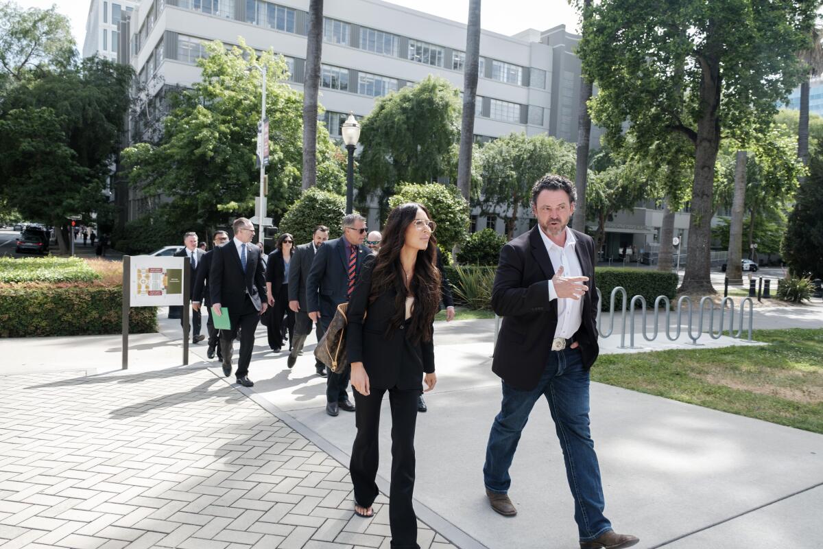 A group of people walks across a courtyard.