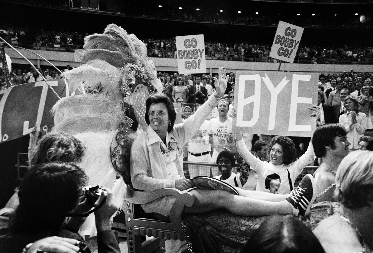Billie Jean King waves to the crowd as she is carried on a throne by four men into the Houston Astrodome.