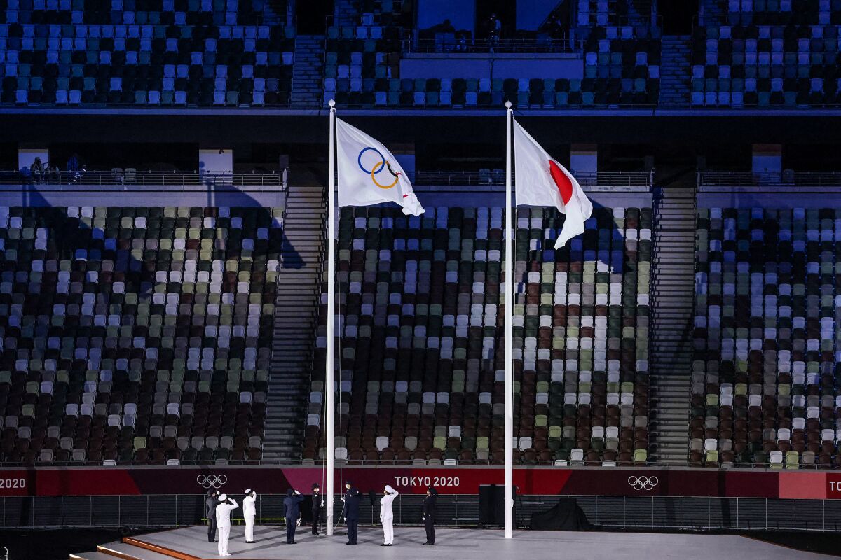 The Olympic flag is raised in front of empty seats at the Tokyo 2020 Olympics Opening Ceremony at Olympic Stadium. 