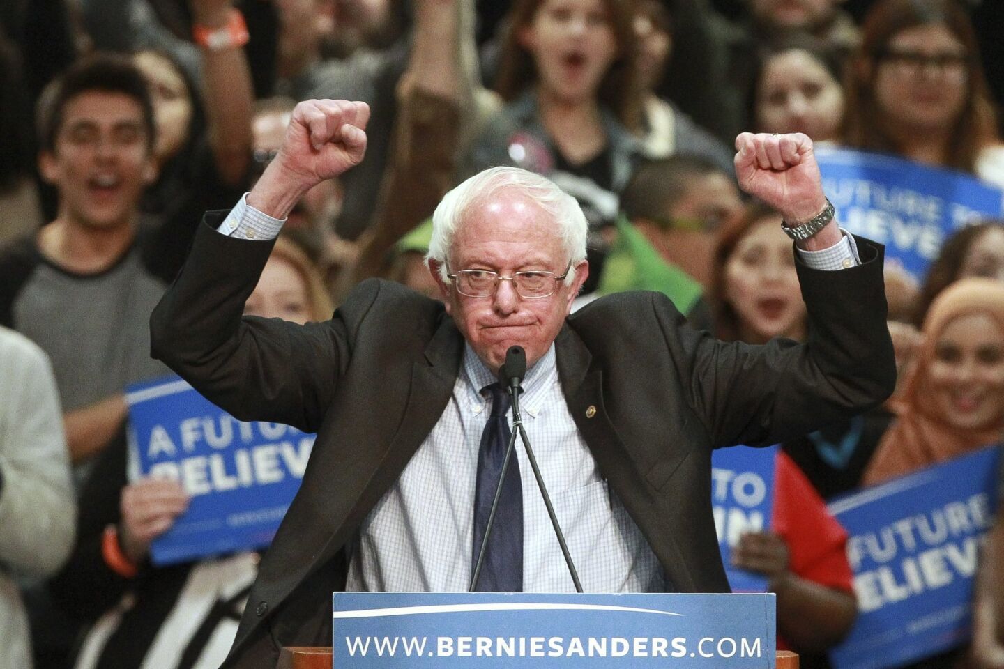 Democratic presidential candidate Bernie Sanders holds up his fists as he speaks to a crowd of supporters.