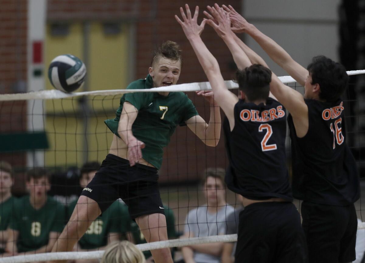 Edison High's James Carpenter, left, hits against Huntington Beach during the fourth set of a Sunset Conference crossover match on Wednesday.