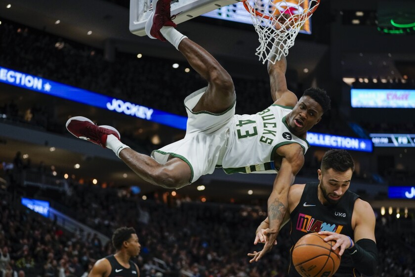 Milwaukee Bucks' Thanasis Antetokounmpo dunks over Miami Heat's Max Strus during the second half of an NBA basketball game Saturday, Dec. 4, 2021, in Milwaukee. (AP Photo/Morry Gash)