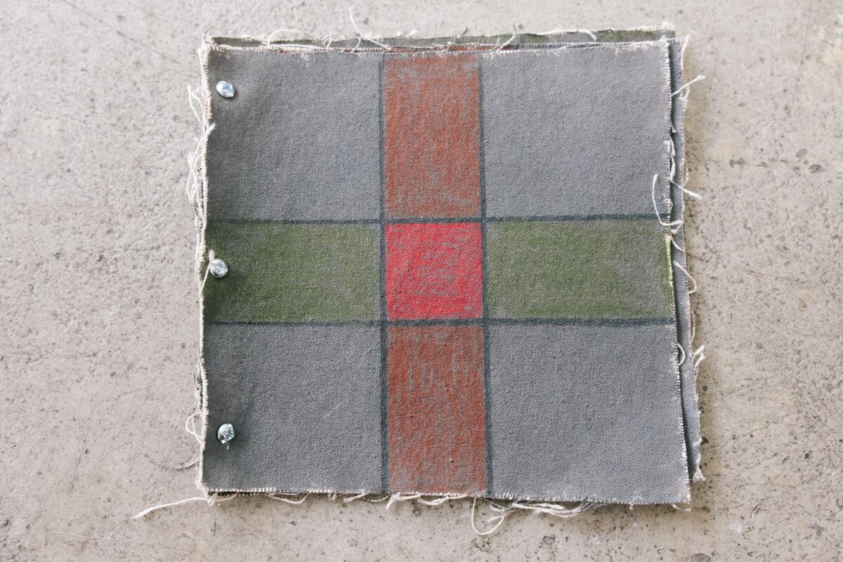 A gray square page with a cross drawn on it in red, green and brown
