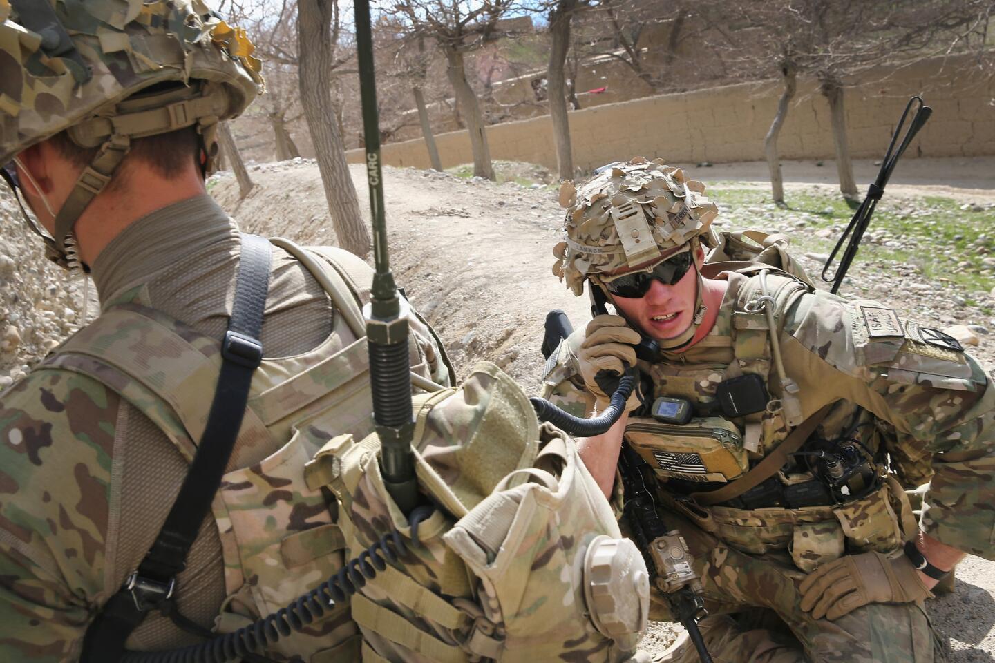 The CIA is planning to close its satellite bases in Afghanistan and pull all its personnel back to Kabul by early summer. The U.S. military says it needs the intelligence the CIA provides. Above, Army 1st Lt. Eric Cannon speaks by radio on patrol near a village south of Kabul.