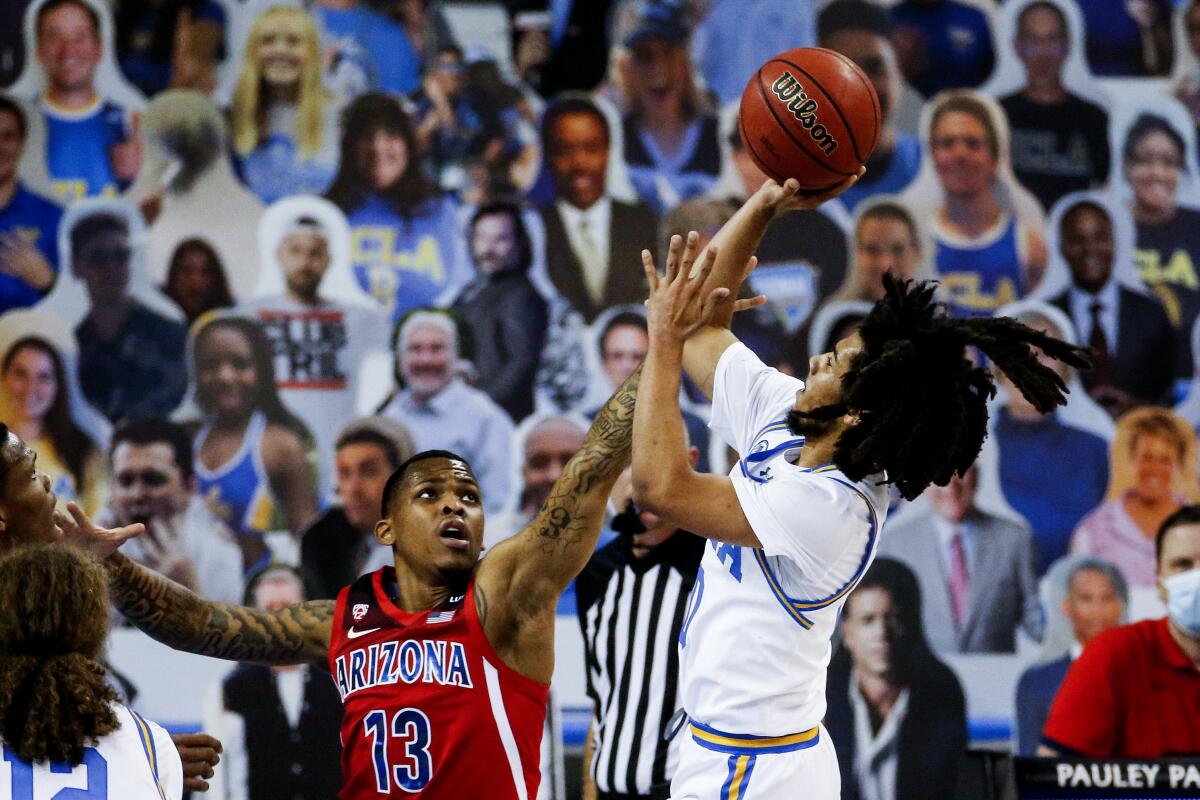 UCLA guard Tyger Campbell shoots against Arizona guard James Akinjo.