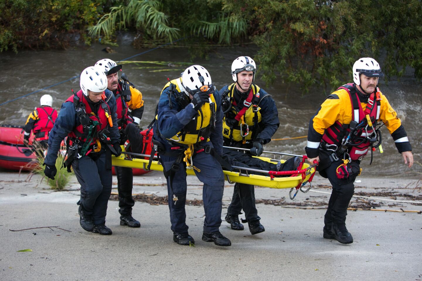 L.A. Fire Department swift water rescue members saved a woman from an island in the middle of the storm-swollen Los Angeles River.