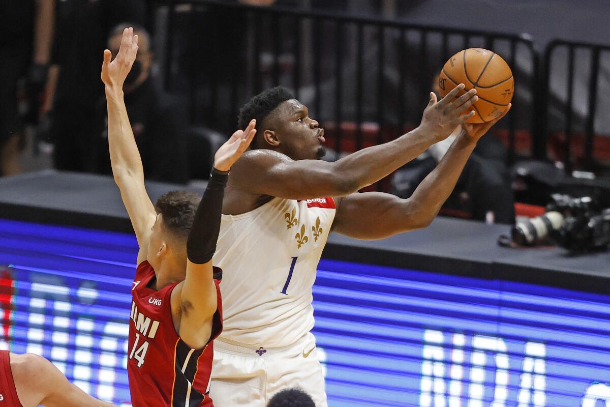 Pelicans forward Zion Williamson gets past Heat guard Tyler Herro for a layup during the second half on Dec. 25, 2020.