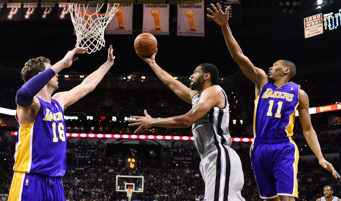 Spurs power forward Tim Duncan attempts a short-range shot between Lakers power forward Pau Gasol (16) and forward Wesley Johnson (11) in the second half Friday night in San Antonio.